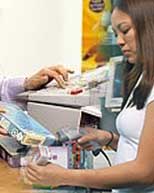 Store Clerk at Cash Register taking inventory with a barcode scanner